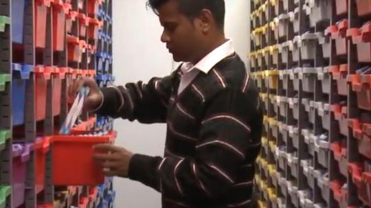 A man searching for items in organised storage containers