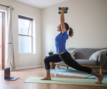 Woman exercising at home using dumbbells